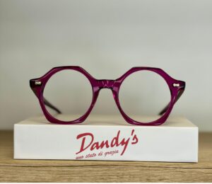 Lunettes magenta géométriques Dandy's sur leur boîte. Monture violette élégante 'Uno stato di grazia'.