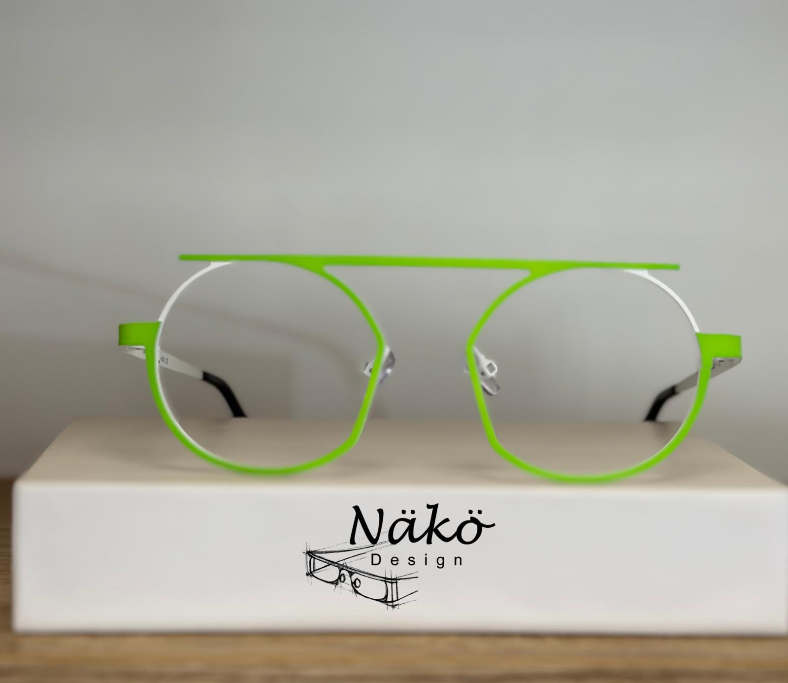 Lunettes Näkö Design vert fluo et blanc, monture géométrique moderne à barre plate sur socle blanc.