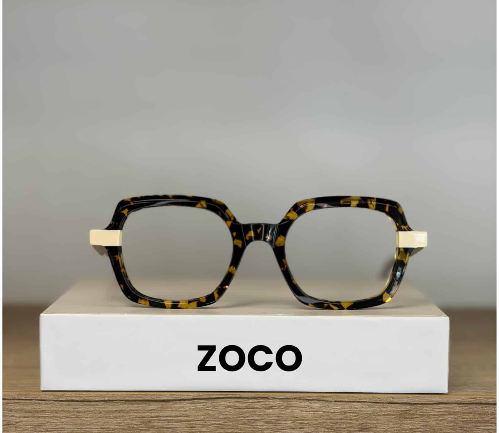 Lunettes ZOCO carrées en écaille de tortue posées sur une boîte blanche.